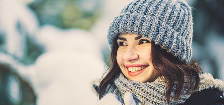 Woman smiling with grey winter hat and scarf