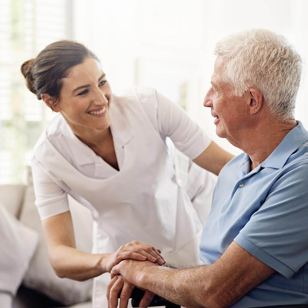 Caregiver laughing with elderly man