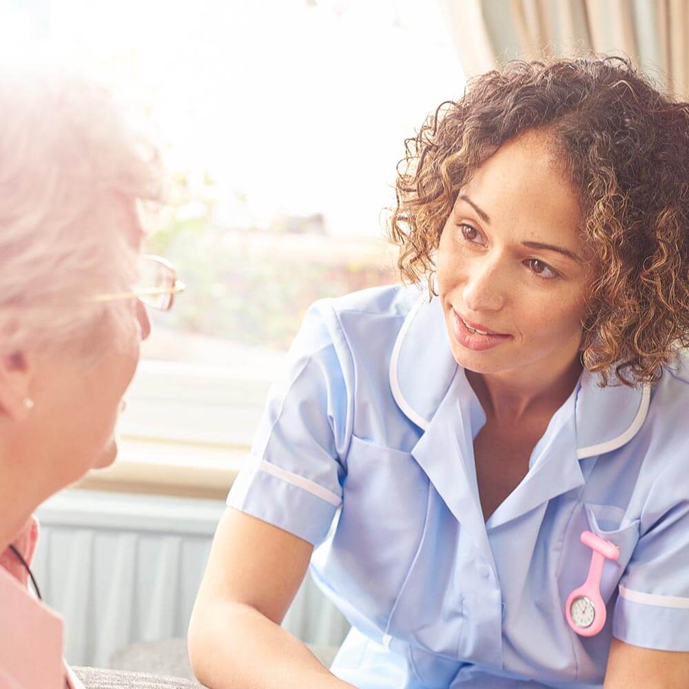 Caregiver speaking to elderly woman