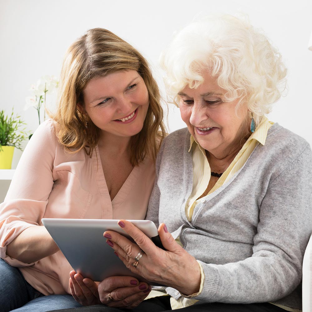 Woman and elderly woman looking on tablet