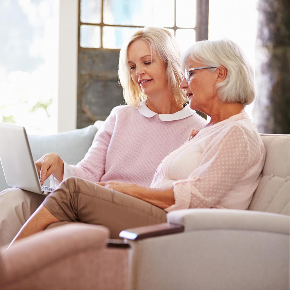A woman and an elderly woman searching on a laptop