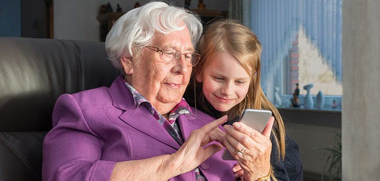 Elderly woman and girl using a smartphone