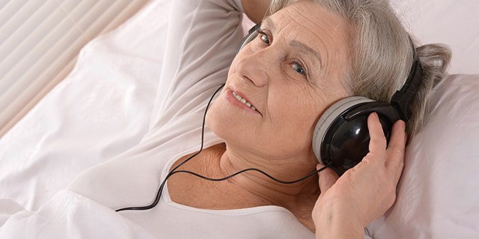 Elderly woman listening to headphones