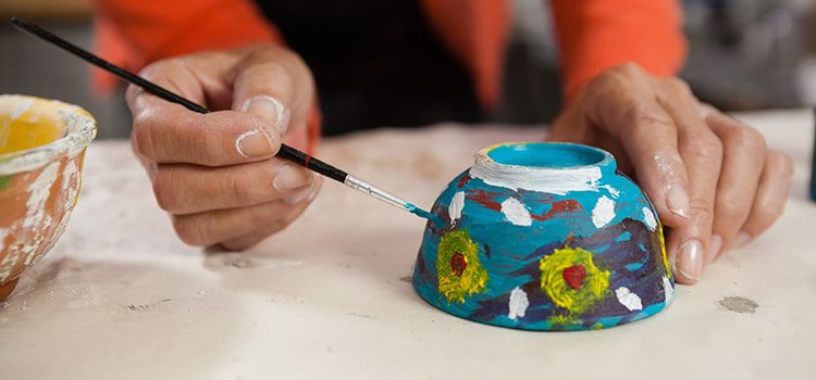 Close up of woman pottery painting