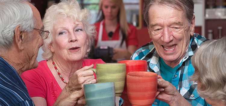 Group of elderly people toasting their hot drinks