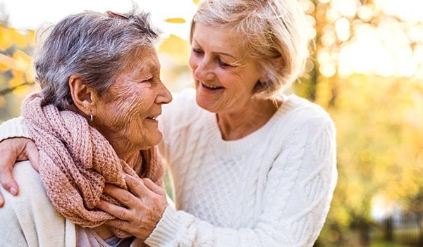 Two elderly women laughing and bonding