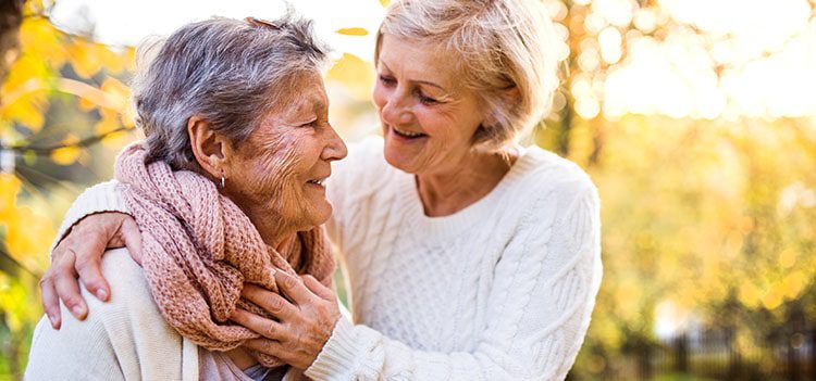 Two elderly women laughing and bonding