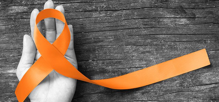 Orange multiple sclerosis awareness sash in hand