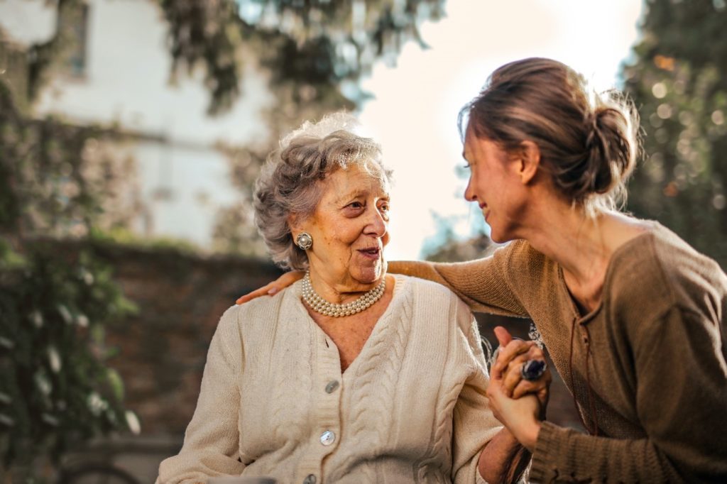 elderly lady smiling and in conversation with younger female