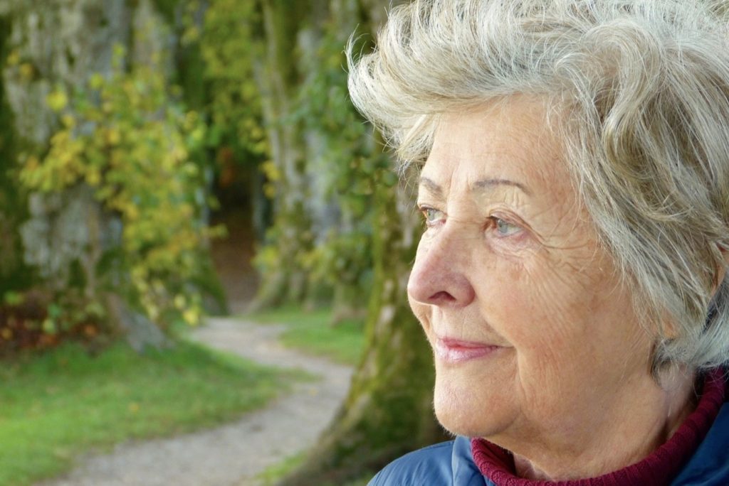 Elderly lady outside in a garden, smiling