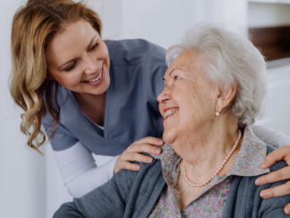 Elderly woman and carer laughing together