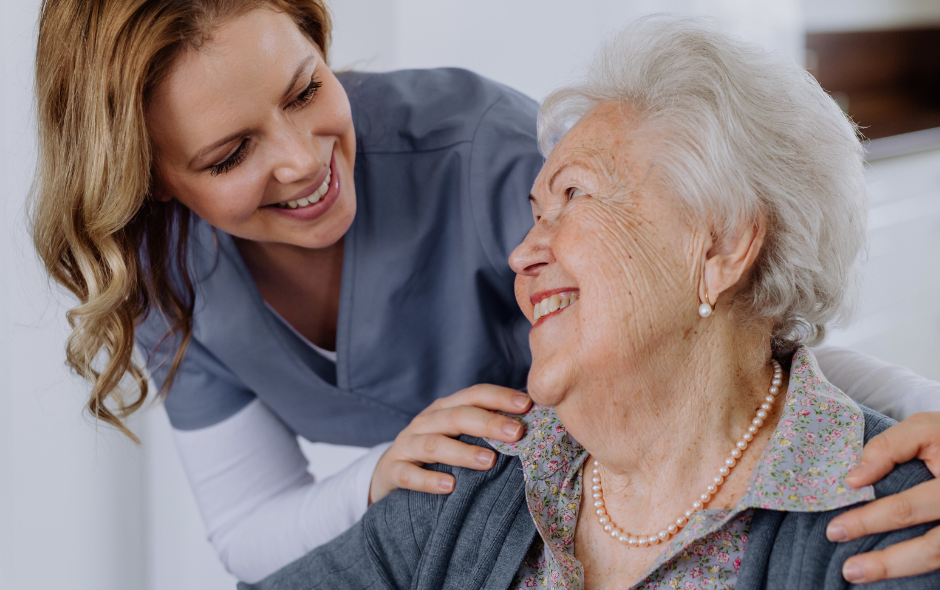 Elderly woman and carer laughing together